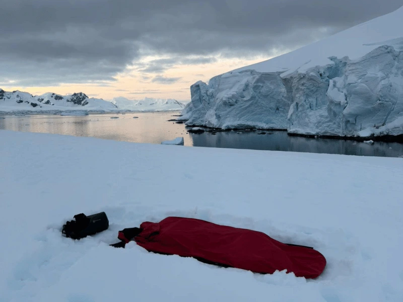 Expedition cruise guest camping overnight on the snow in Antarctica
