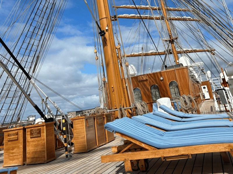 Wooden sun loungers beneath the masts and rigging on Sea Cloud Spirit’s sun deck