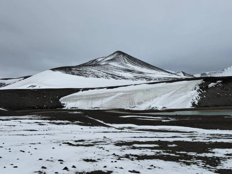 Black volcanic landscape covered with snow on Deception Island