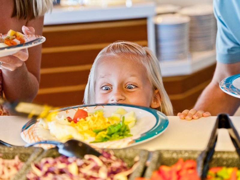 Young child choosing food from a cruise ship buffet