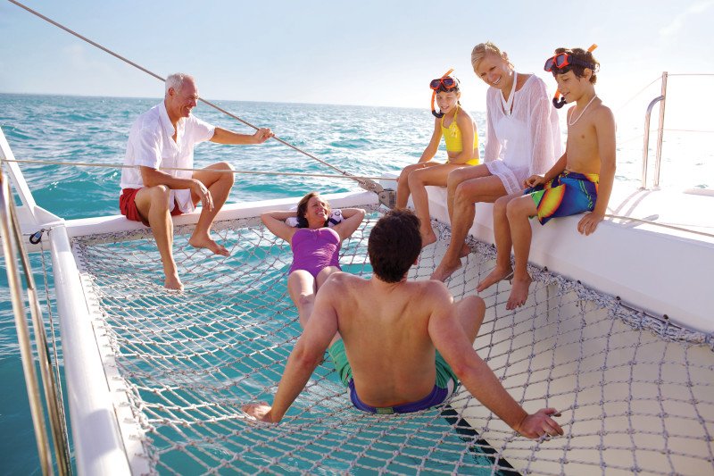 Multigenerational family enjoying a catamaran excursion in the Caribbean