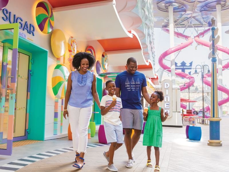 Family walking through a colourful children’s area aboard a Royal Caribbean ship