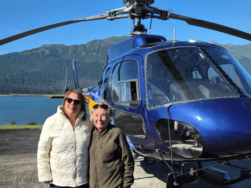 Sarah standing beside a helicopter before a glacier excursion in Alaska